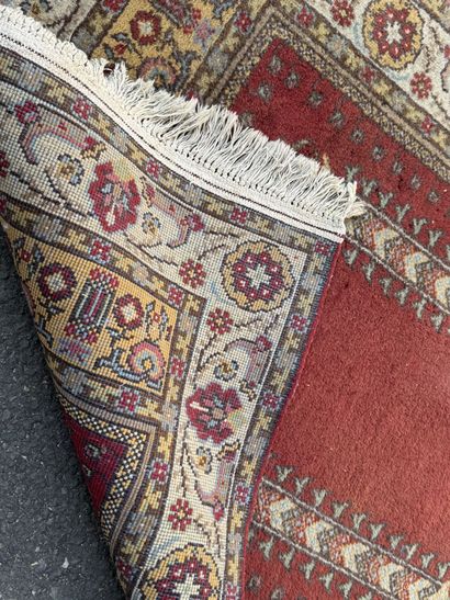 Hand-knotted wool rug featuring a red background...