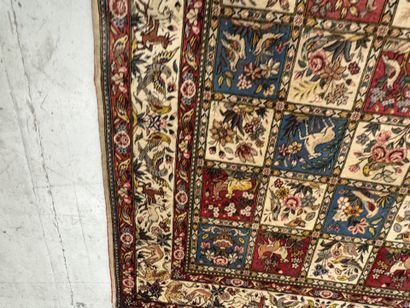 A large hand-knotted wool rug featuring stylized...