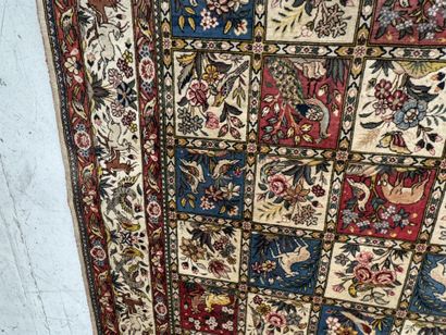 A large hand-knotted wool rug featuring stylized...