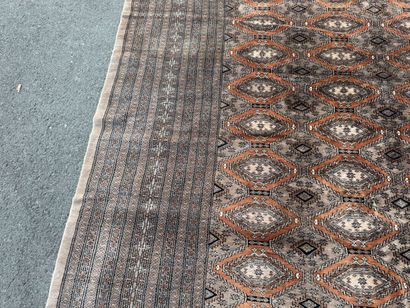 Large hand-knotted wool rug featuring stylized...