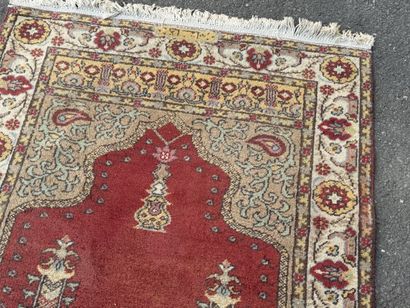 Hand-knotted wool rug featuring a red background...