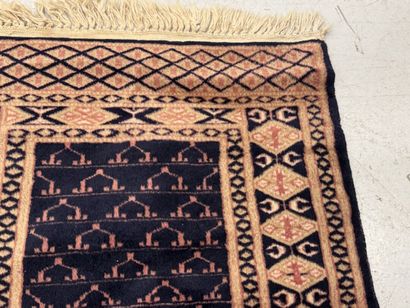 Small hand-knotted wool rug with stylized...