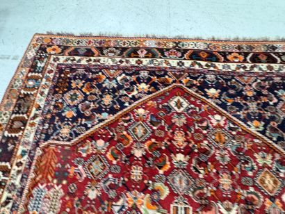 A large hand-knotted wool rug featuring stylized...