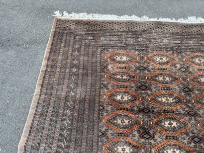 Large hand-knotted wool rug featuring stylized...