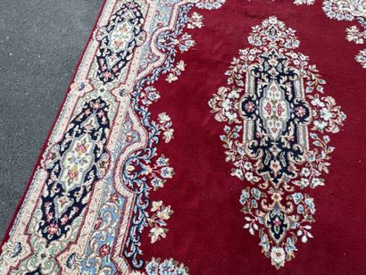 A large hand-knotted wool rug featuring a...