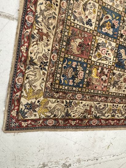 A large hand-knotted wool rug featuring stylized...
