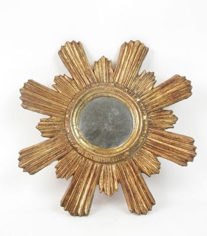 Miroir en bois sculpté doré en forme de soleil.
Travail...