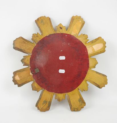 Miroir en bois sculpté doré en forme de soleil.
Travail...