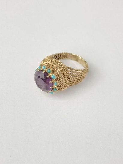 Gold ring with a round purple stone** surrounded...
