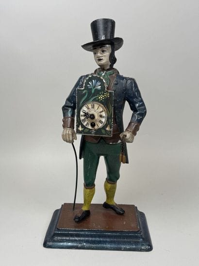 Polychrome cast-iron clock depicting a peddler.
H....