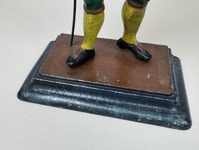 Polychrome cast-iron clock depicting a peddler.
H....