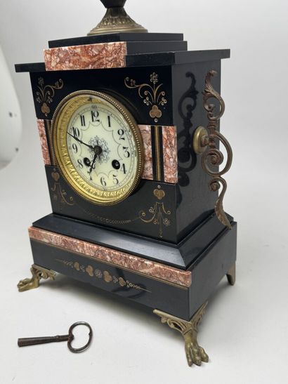 Black marble clock with a circular dial featuring...