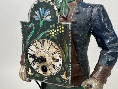 Polychrome cast-iron clock depicting a peddler.
H....