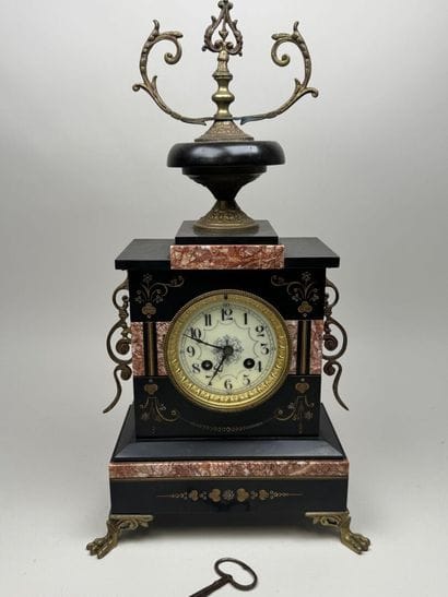 Black marble clock with a circular dial featuring...