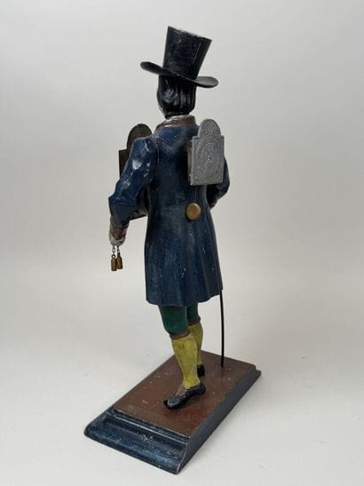 Polychrome cast-iron clock depicting a peddler.
H....