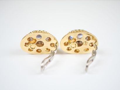 A striking pair of oval ear clips in 18K...