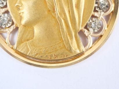 A circular religious medal in 18K (750‰)...