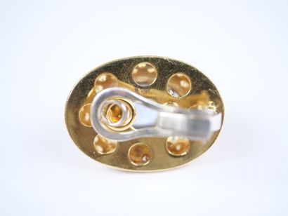 A striking pair of oval ear clips in 18K...