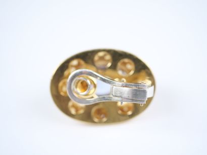 A striking pair of oval ear clips in 18K...