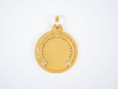 A circular religious medal in 18K (750‰)...