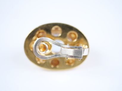 A striking pair of oval ear clips in 18K...