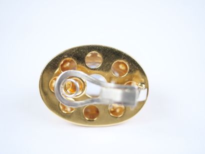 A striking pair of oval ear clips in 18K...
