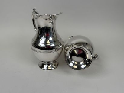 Deux grands pichets à eau en métal argenté.
H....