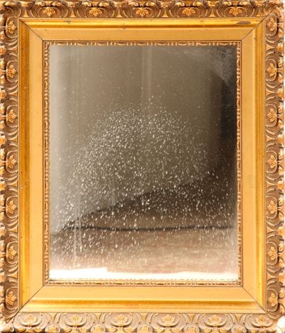 Wooden and gilded stucco mirror with volutes...