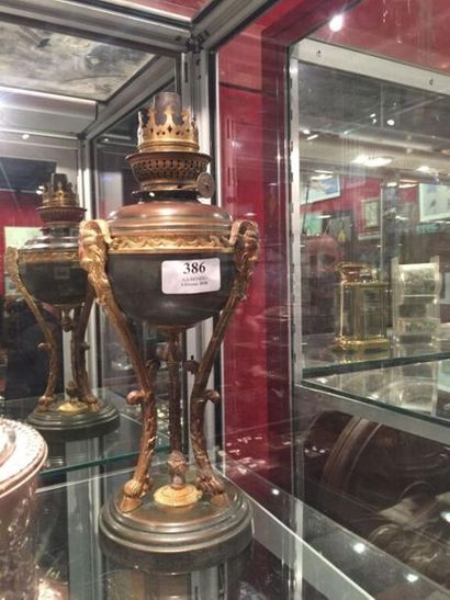 Une lampe à pétrole en tôle et bronze à décor...