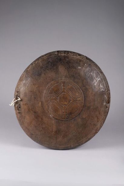 Plat en bois sombre dense, circulaire, avec...