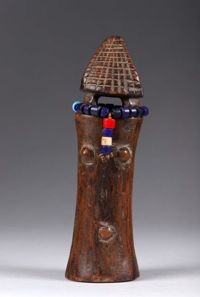 Poupée à la tête conique. Collier de perles...