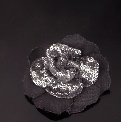 * CHANEL.
Broche Camélia en tissu noir rebrodé...