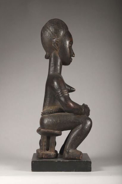 Female figure seated on her throne in wood...