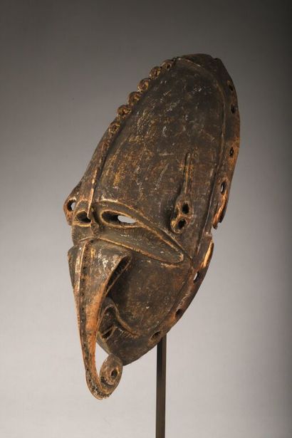 Large, oblong mask with long nose curling...