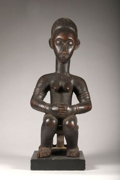 Female figure seated on her throne in wood...