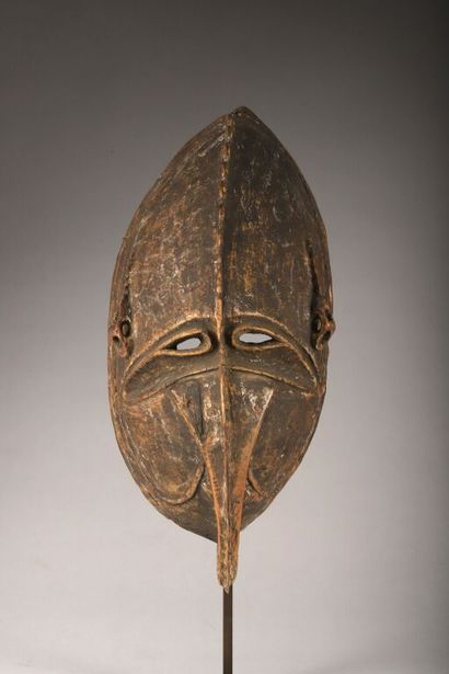Large, oblong mask with long nose curling...