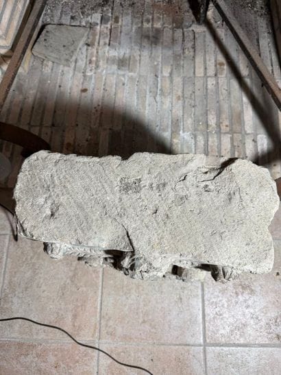 Stone carved with a coat of arms surmounted...