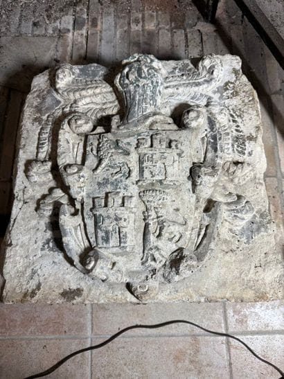 Stone carved with a coat of arms surmounted...