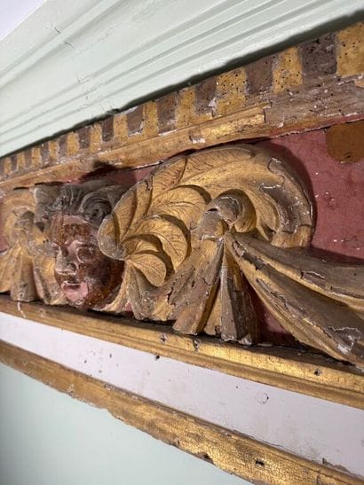 Carved wood paneling with ochre and white...