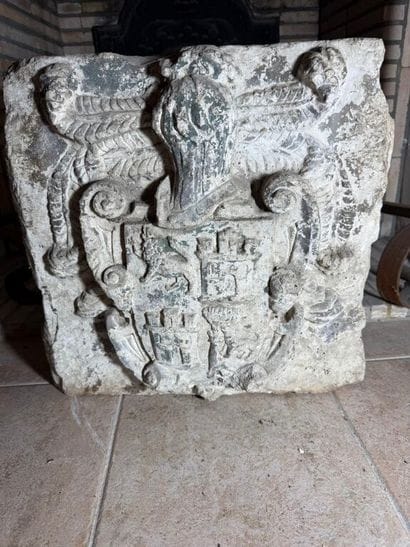 Stone carved with a coat of arms surmounted...