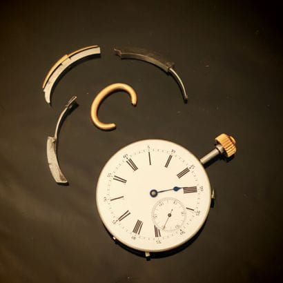 Metal case containing an as-is striking watch...