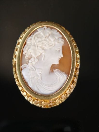 A 750‰ gold brooch featuring a shell cameo...