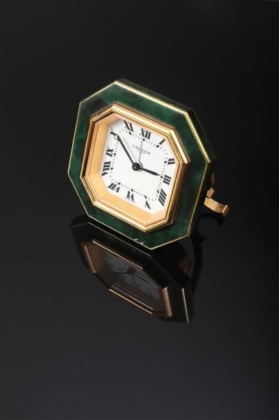 CARTIER.
Réveil en métal doré et émail vert...
