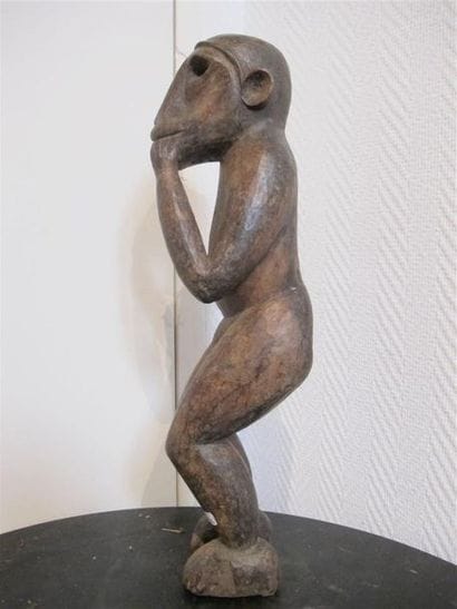 Singe en bois sculpté, debout, les mains...