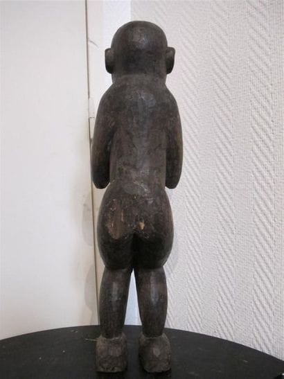 Singe en bois sculpté, debout, les mains...