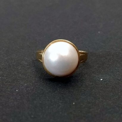 Bague ne or jaune 18k serti d'une demi perle...