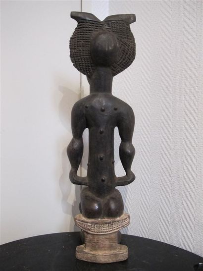 Statuette of a woman sitting on a stool,...