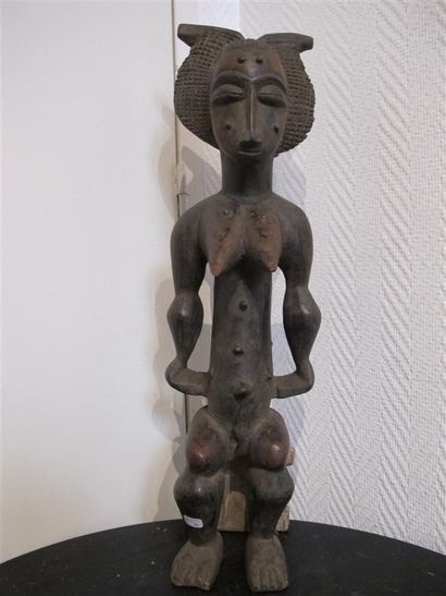Statuette of a woman sitting on a stool,...