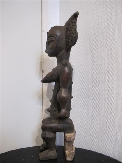 Statuette of a woman sitting on a stool,...