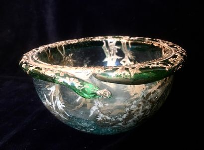 A round glass bowl decorated with gold inclusions...